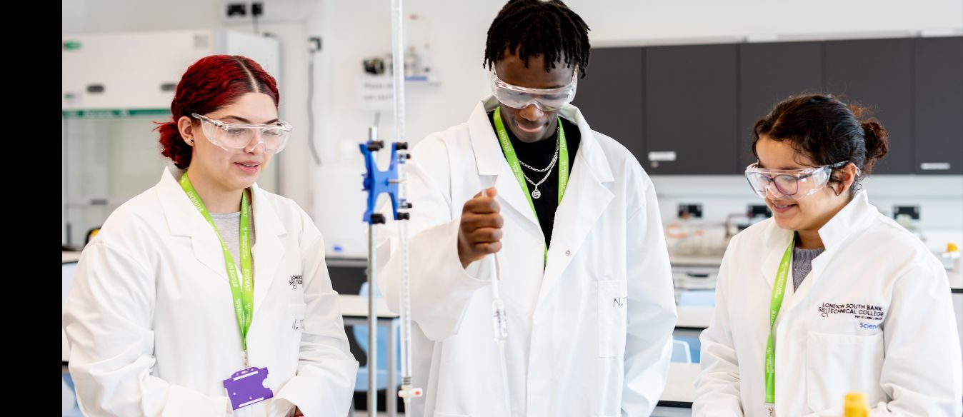 Three LSBTC science students wearing lab coats in a laboratory, standing side by side and appearing to collaborate on a project.