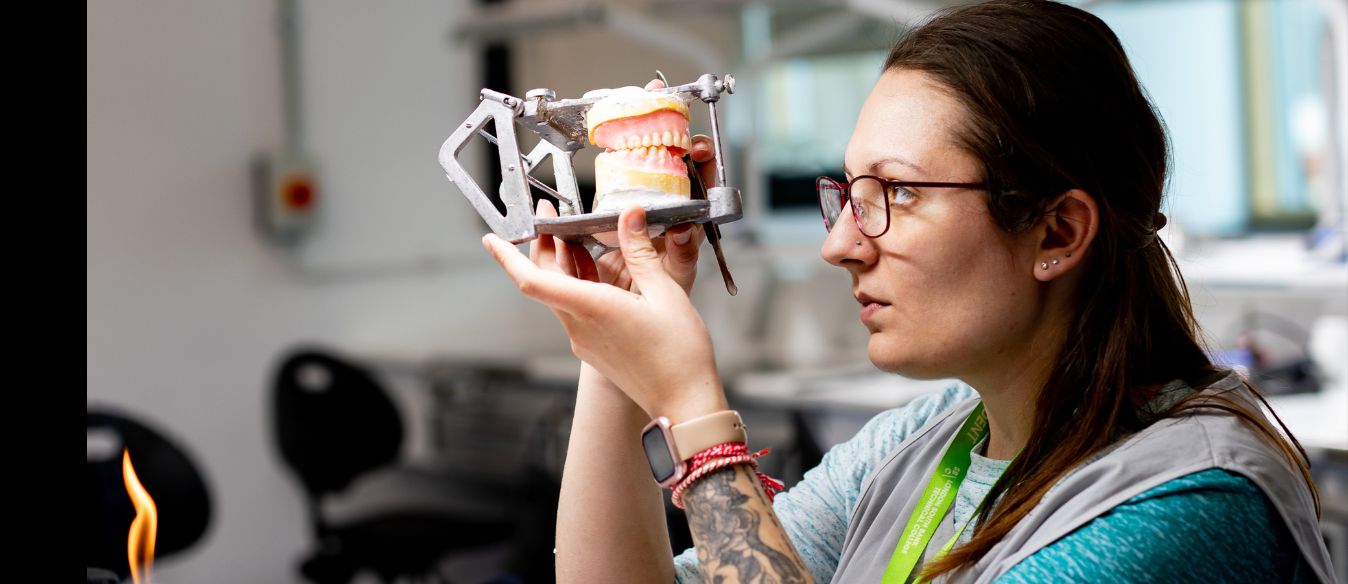 A London South Bank Technical College dental student holding a small teeth model, demonstrating dental health and education.